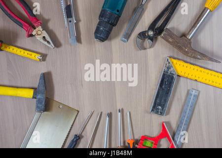 Verschiedene Werkzeuge auf einem hölzernen Hintergrund. Hammer, Bohrer, Zangen. Schraubendreher, Lineal, schneiden Zangen Stockfoto