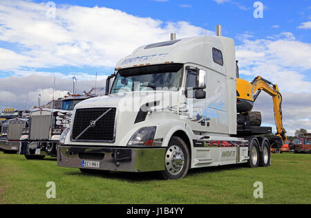 ALAHARMA, Finnland - 12. August 2016: Weiße Volvo VNL 64T 670 Jahr 2004 mit kleinen Bagger und anderen konventionellen LKW auf dem Display auf die jährlichen Pow Stockfoto