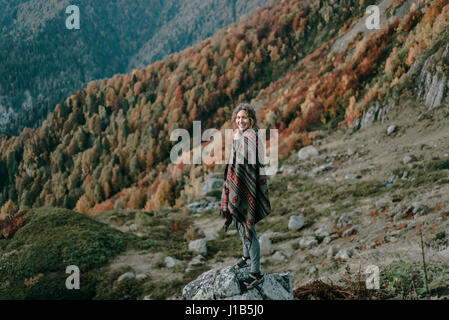 Kaukasische Frau lächelnd am Berg mit Blick auf Tal Stockfoto