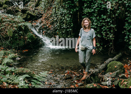 Kaukasische Frau stehen in der Nähe von Waldbach Stockfoto