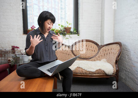 Asiatin Video-Chats auf laptop Stockfoto