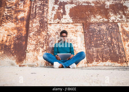 Afroamerikanische Frau sitzt am Boden mit digital-Tablette Stockfoto