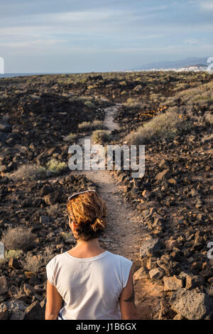 Kaukasische Frau auf Weg durch Felsen Stockfoto