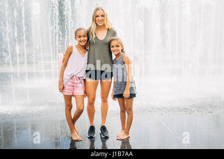 Schwestern posieren in der Nähe von Brunnen Stockfoto