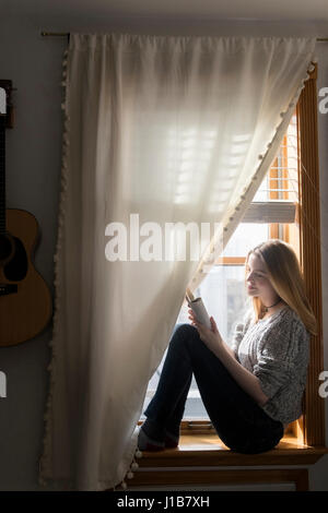 Lächelnde Frau im Fenster, mit digital-Tablette Stockfoto