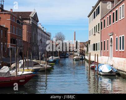 Kanal und Boote in Guidecca Venedig an einem sonnigen Tag mit blauem Himmel und Brücke Stockfoto