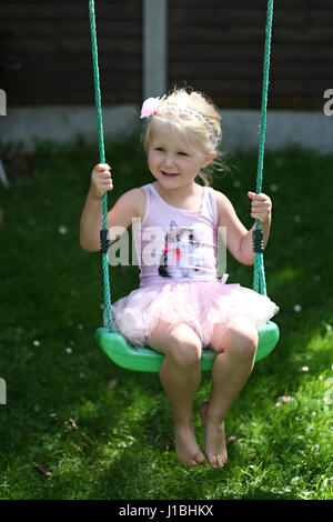 Blonde Kind tutu Schwingen schwingen garten sommer, Kindheit Konzept, Freiheit, unbeschwerte, glückliche Zeiten, Zeit ihres Lebens, Freude Konzept, glücklich Stockfoto