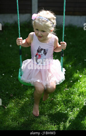 Blonde Kind tutu Schwingen schwingen garten sommer, Kindheit Konzept, Freiheit, unbeschwerte, glückliche Zeiten, Zeit ihres Lebens, Freude Konzept, glücklich Stockfoto