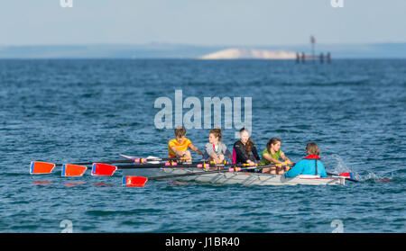 4 junge Frauen Rudern crew in einem Vierer-Quad (4 X +) Skiff Ruderboot mit einem Cox, Rudern auf dem Meer. Stockfoto