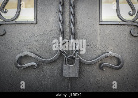 Alte Schleuse an einer Kette auf einer Eisentür