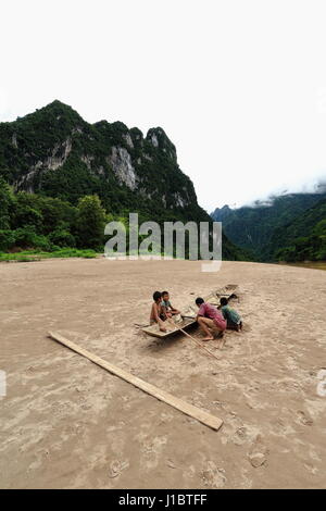 Nam Ou Fluss, Laos-Oktober 9, 2015: lokale Slowboats Segel der Fluss als Haupttransport bedeutet Mangel an land Straßen. Bootsmann repariert seine Zeile Stockfoto