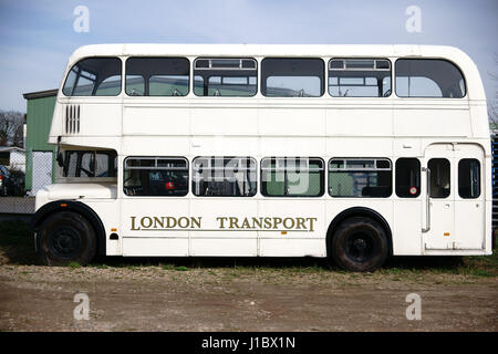 Die Seitenansicht des einen alten ausrangierten Doppeldecker-Bus auf einem Schrottplatz. Stockfoto