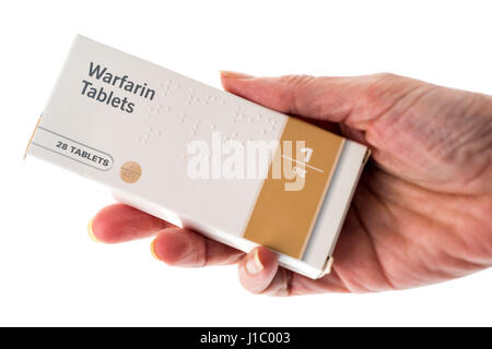 Weibliche Hand hält Paket von Warfarin Tabletten Stockfoto