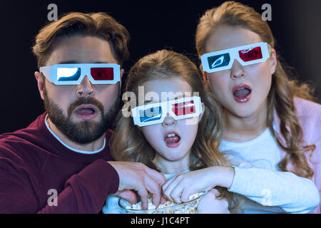 Schockiert Familie in 3d Brille Film und Essen Popcorn aus Schüssel Stockfoto