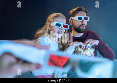Schockiert Vater und Tochter in 3d Brille Film und Essen popcorn Stockfoto