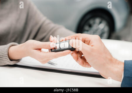 Close-up Teilansicht des Händlers geben Autoschlüssel an neuen Eigentümer Stockfoto