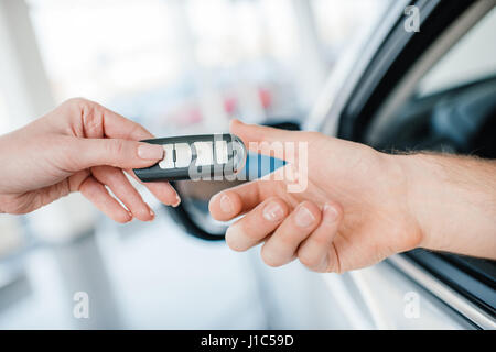 Close-up Teilansicht des Händlers geben Autoschlüssel an neuen Eigentümer Stockfoto