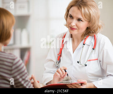 Arzt Frau freundliche Kommunikation mit Patienten im Büro Stockfoto