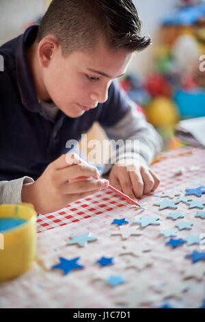 Hispanische junge Malerei Sterne am Tisch Stockfoto