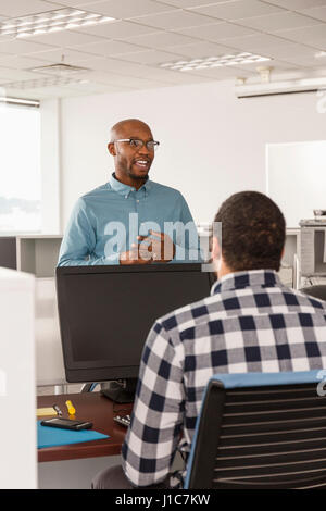 Männer sprechen im Büro in der Nähe von computer Stockfoto