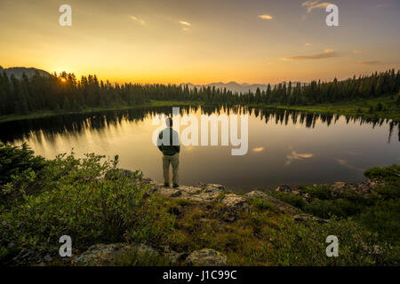 Whit Richardson stehend auf Felsvorsprung Blick auf den Kratersee, West Nadel Mountains, Colorado. Stockfoto