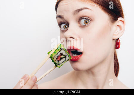 Kaukasische Frau Sushi mit Stäbchen zu essen Stockfoto