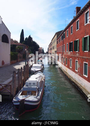 alte rote Buidking in Guidecca Venedig mit Kanalbrücke und Boote Stockfoto