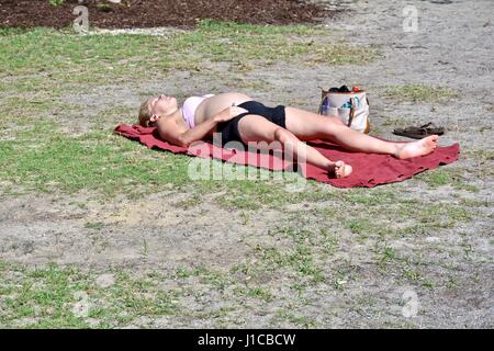 Schwangere Frau Sonnenbaden im Feld Stockfoto