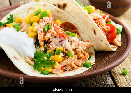 Hausgemachte langsame Herd Chicken Taco mit Mais auf rustikale Keramik-Platte auf Holztisch, mexikanischen Stil serviert Stockfoto