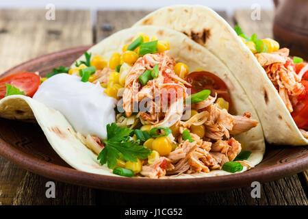 Hausgemachte langsame Herd Chicken Taco mit Mais auf rustikale Keramik-Platte auf Holztisch, mexikanischen Stil serviert Stockfoto