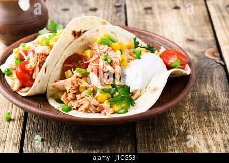 Hausgemachte langsame Herd Chicken Taco mit Mais auf rustikale Keramik-Platte auf Holztisch, mexikanischen Stil serviert Stockfoto