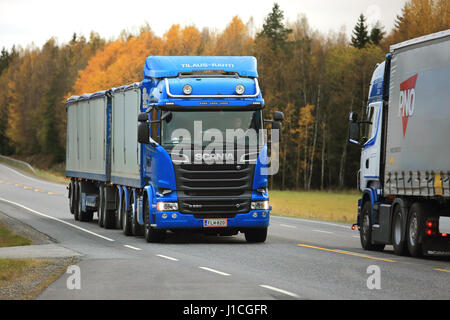 KAARINA, Finnland - 9. Oktober 2016: Blaue Scania R580 Kombination Fahrzeug von Kosti Saukko Oy erfüllt eine weitere Scania-Transport-LKW auf der Straße auf einem clou Stockfoto