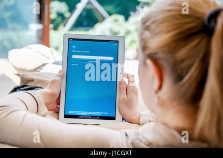 WROCLAW, Polen - 10. April 2017: Frau startet Airbnb Anwendung auf Lenovo Tablet. Airbnb ist ein Online-Marktplatz und Gastfreundschaft service Stockfoto