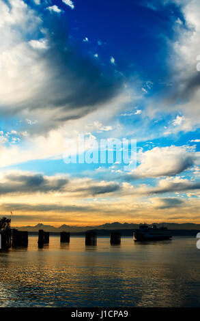 Eine wunderschöne Landschaft einer Fähre, die in einem Dock gegen die Olympic Mountains während des Sonnenuntergangs Stockfoto