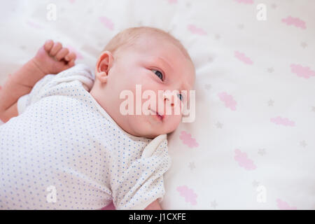 Detail-Aufnahme von Babys Hand in pink Sheets mit Wolkenmuster. Stockfoto