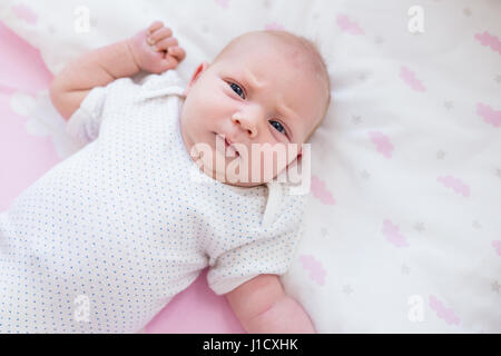 Detail-Aufnahme von Babys Hand in pink Sheets mit Wolkenmuster. Stockfoto