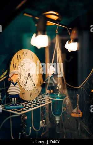 Dekorative Uhr und Figuren auf der Theke in einem Geschäft Stockfoto