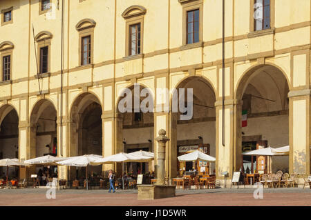 Cafés und Restaurants unter dem gelben Fassade und eleganten Bögen der Loggia del Vasari - Arezzo, Italien, 24. September 2011 Stockfoto