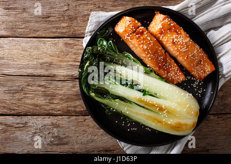 Verglaste Lachsfilet mit Sesam und gebratenen Kohl Bok Choy Nahaufnahme auf einer Platte. horizontale Ansicht von oben Stockfoto