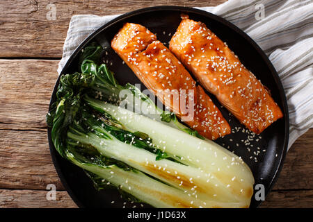 Lachs in Honig-Soja Glasur und gebratenem Chinakohl Nahaufnahme auf einer Platte. horizontale Ansicht von oben Stockfoto