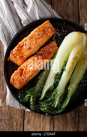 Lachs in Honig-Soja Glasur und gebratenem Chinakohl Nahaufnahme auf einer Platte. Vertikale Ansicht von oben Stockfoto