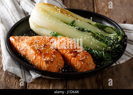 Verglaste Lachsfilet mit Sesam und gebratenen Kohl Bok Choy Nahaufnahme auf einer Platte. horizontale Stockfoto