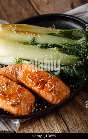 Lachs in Honig-Soja Glasur und gebratenem Chinakohl Nahaufnahme auf einer Platte. vertikale Stockfoto