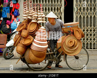 Straßenhändler und Straßenhändler verkaufen Hüte, Obst, Gemüse, Reinigungsprodukte, ihren Lebensunterhalt auf den Straßen von Hanoi, Vietnam Stockfoto