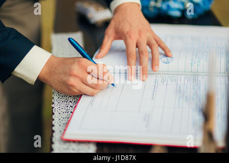 Brautpaar setzen ihre Unterschriften im Akt der Registrierung einer Ehe Stockfoto