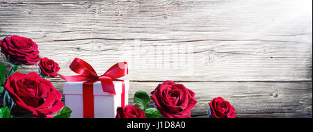 Geschenk-Box und Rosen auf Vintage Holz-Hintergrund Stockfoto