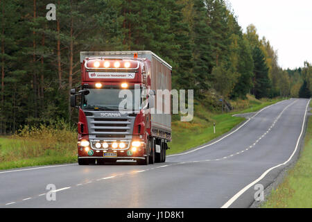 SALO, Finnland - 17. SEPTEMBER 2016: Rote Scania halb cargo Truck von Savakko Transport auf ländlichen Straßen. Der Fahrer blinkt das Fernlicht leuchtet kurz auf. Stockfoto