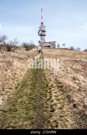 Devin Hill mit Kommunikation Tower, Wanderweg und Wiese mit wenigen Bäumen in pavlovske vrchy in Südmähren im frühen Frühling mit Stockfoto