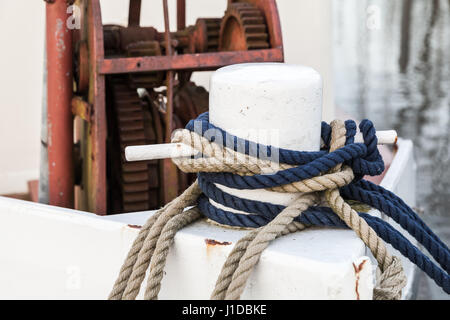 Weißer Schleife Poller mit Seilen auf alte Schiffsdeck montiert Stockfoto