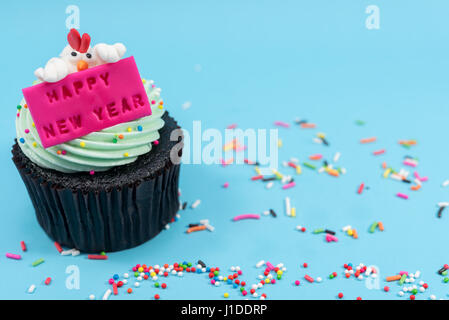 2017 Neujahr Huhn Cupcake auf blauem Hintergrund Stockfoto